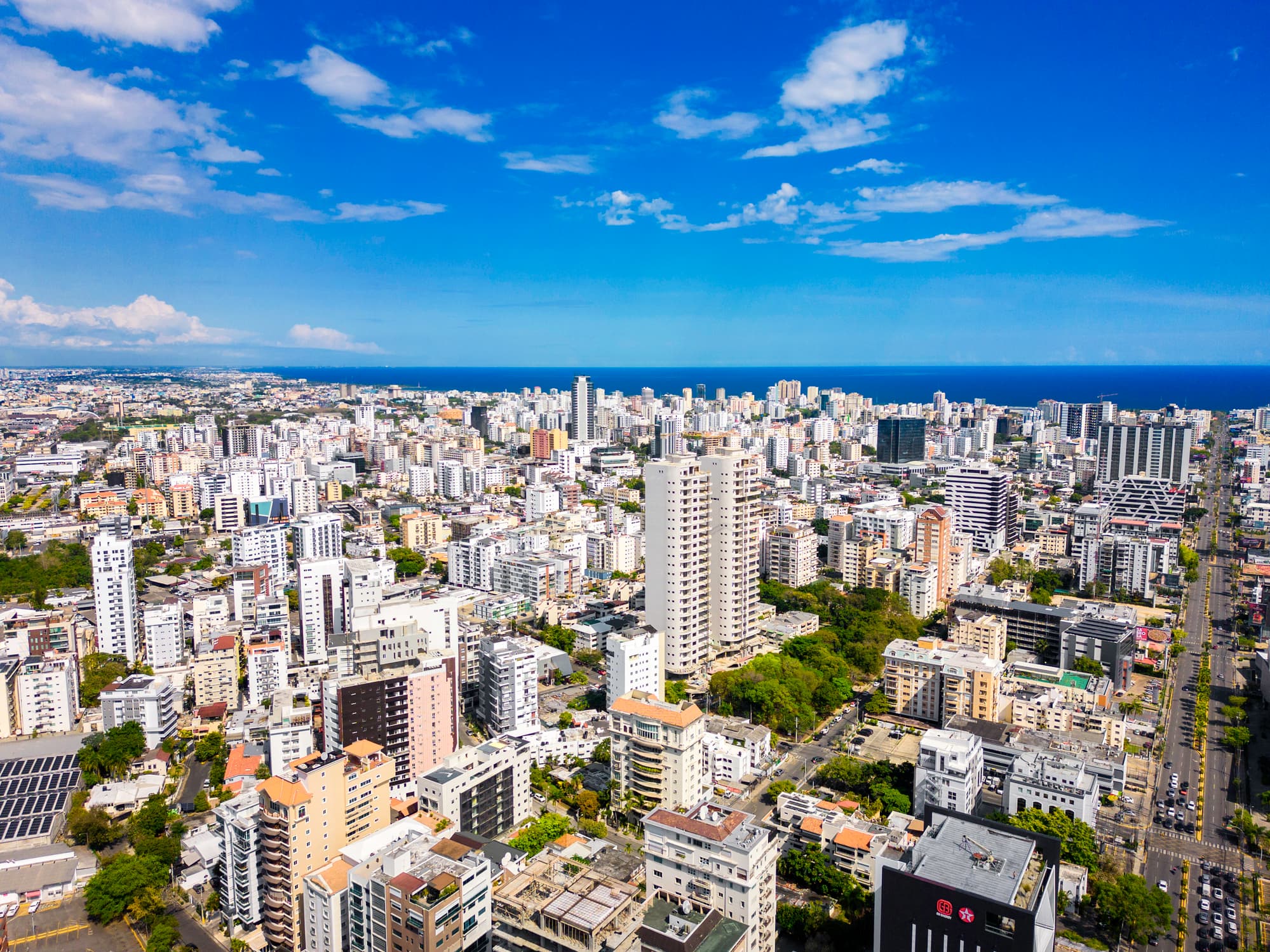 Aerial view of high-rise towers across the Santo Domingo skyline meeting the Caribbean coast, where Americans hold Dominican Republic residence permits