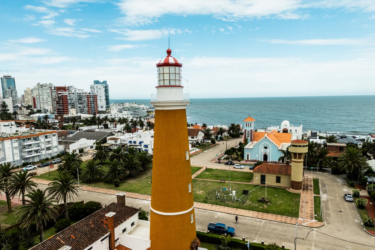 The orange Punta del Este lighthouse rises above the peninsula skyline, a coastal destination drawing Americans moving to Uruguay
