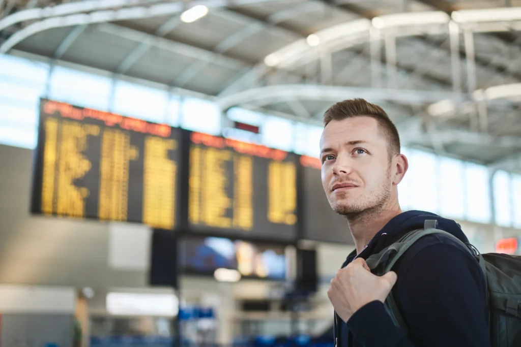 Why More Americans Are Choosing to Live Abroad 9 man with backpack at airport portrait of tourist 2025 02 16 10 55 24 utc