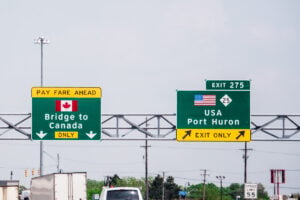 US - Canada border highway direction sign, symbolizing the increase of Americans moving to Canada.