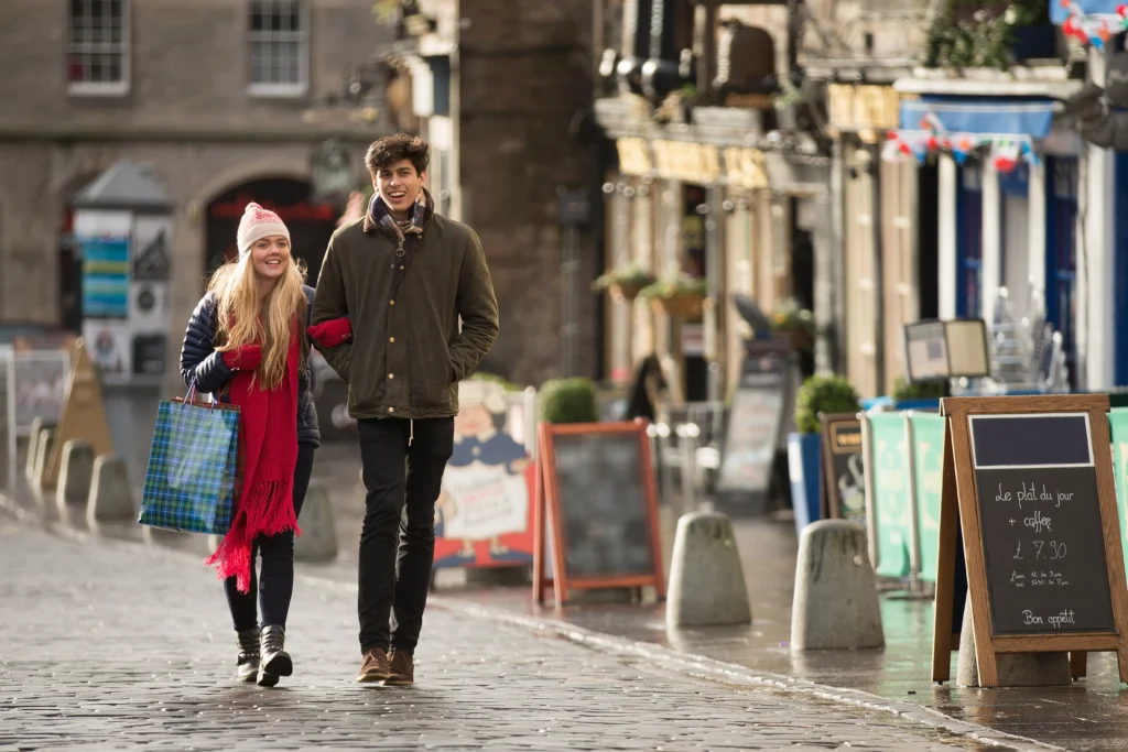 Why a Growing Number of Americans are Considering to Move to Edinburgh Amid U.S. Social Fragmentation 3 a-young-couple-shop-in-the-grassmarket-in-edinburg