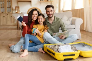 joyful-parents-and-daughter-sitting-with-suitcase
