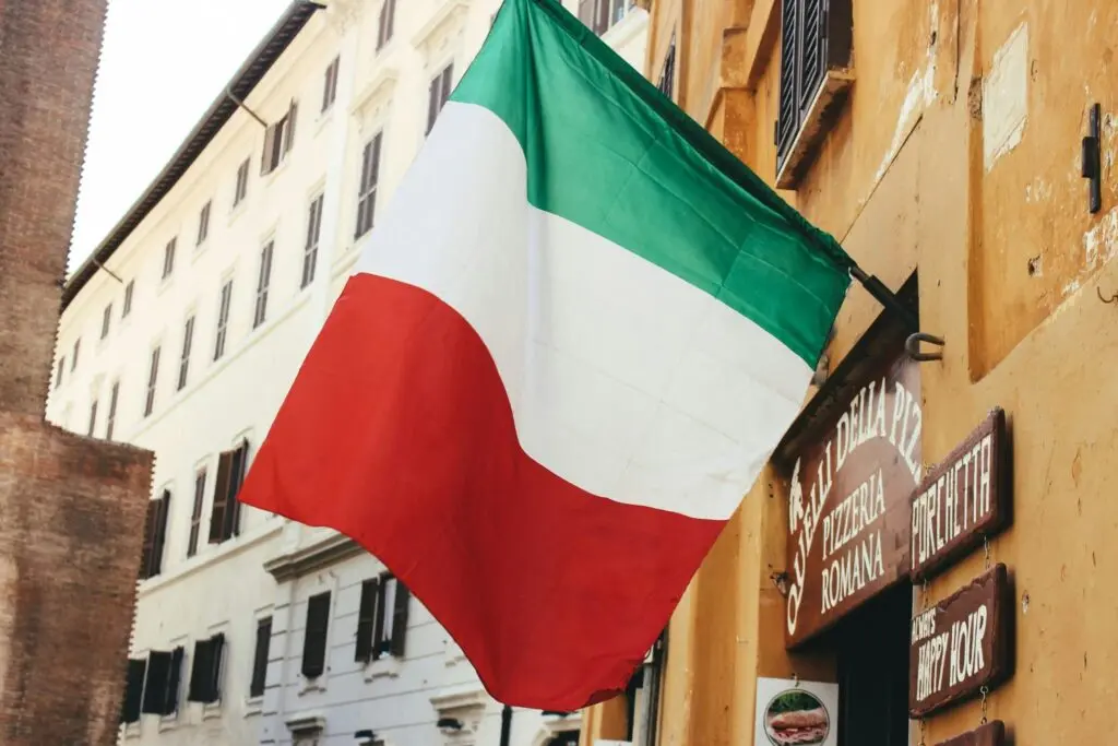 Italy Approves Sweeping Consular Reform: Italian Citizenship Applications Moving to Rome 4 An Italian flag waves in front of a building; Italian citizenship applications reform legislation will take effect in 2025 if passed in Italy’s Senate, with huge implications for Italian diaspora communities.