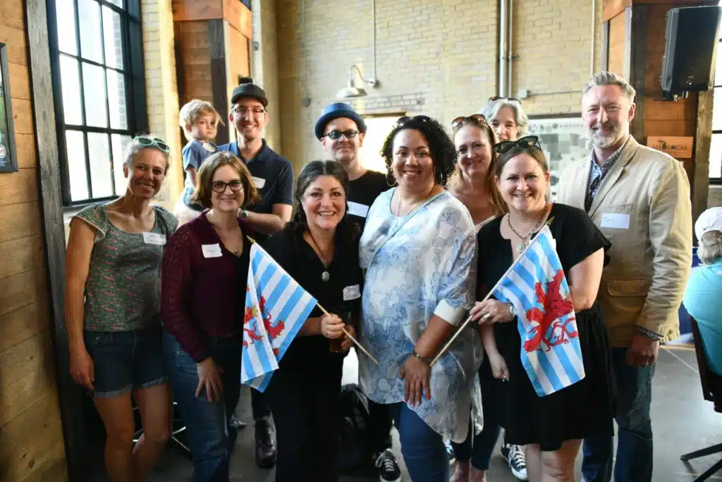 Rapid Surge of New Luxembourg Dual Citizens Living in the United States 2 A large, diverse group of people is posing for a photo indoors, likely at a social or community event.