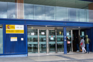 People entering the immigration office in Pamplona, symbolizing the impact of the Spain migrant regularization program.