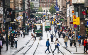 Pedestrians and HSL trams on Aleksanterinkatu in central Helsinki, where Finland permanent residence rules tightened to require 6 years and a language test in 2026
