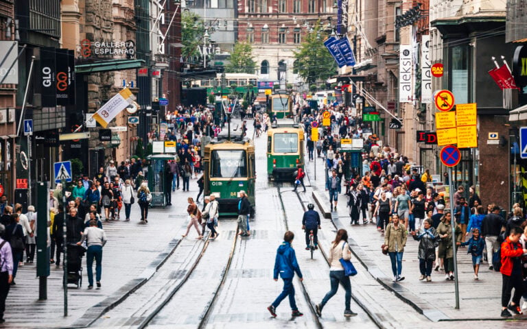 American Emigration Revue 42 Pedestrians and HSL trams on Aleksanterinkatu in central Helsinki, where Finland permanent residence rules tightened to require 6 years and a language test in 2026