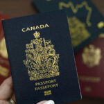 Hand holding a Canadian passport, the document Americans qualifying for Canadian citizenship by descent apply to receive.