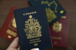 Hand holding a Canadian passport, the document Americans qualifying for Canadian citizenship by descent apply to receive.