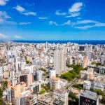 Aerial view of high-rise towers across the Santo Domingo skyline meeting the Caribbean coast, where Americans hold Dominican Republic residence permits