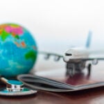 A stethoscope rests on a US passport, illustrating Medicare access questions for Americans abroad
