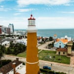 The orange Punta del Este lighthouse rises above the peninsula skyline, a coastal destination drawing Americans moving to Uruguay