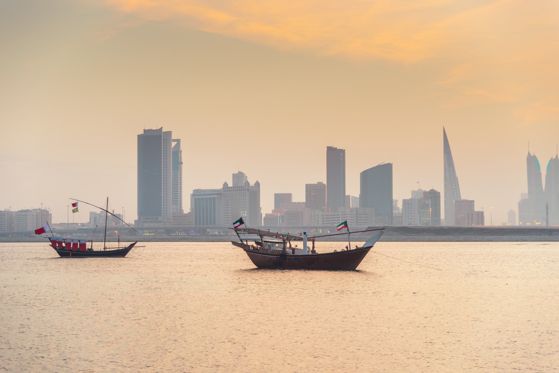 American Emigration Revue 9 Traditional dhows anchored at sunset before the Manama skyline, the Bahraini capital where most Americans in Bahrain live beyond the naval base.