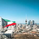 Kuwait City skyline with the national flag and Liberation Tower, where the Kuwait investor residency permit applies