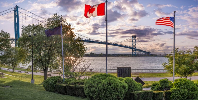 American Emigration Revue 10 Canadian and American flags fly beside the Ambassador Bridge over the Detroit River, the busiest land crossing for Americans in Canada.