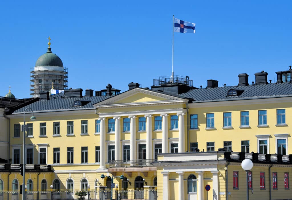 Finland Citizenship Test Becomes Mandatory for Naturalization in 2027 1 Finnish presidential palace in Helsinki flying the national flag, where the Finland citizenship test takes effect in 2027